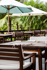 Outdoor restaurant surround palm trees.