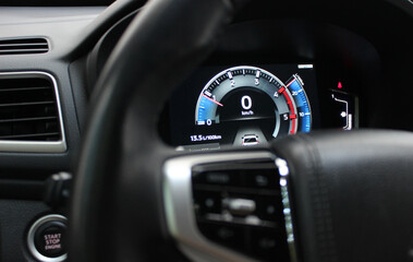 Digital tachometer with colored backlight on the central panel of a modern car