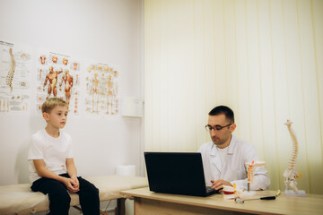 Professional orthopedist examining little patient's in clinic