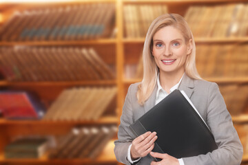 Lawyer, consultant, business owner. Confident woman with file folder smiling indoors, space for text