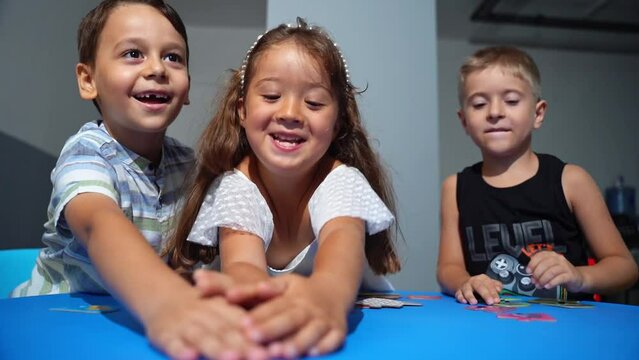 Explorative process Kindergarten students in classroom playing cognitive game activities, decoding puzzles that boost logical thinking and motor skills, all within an interactive learning environment