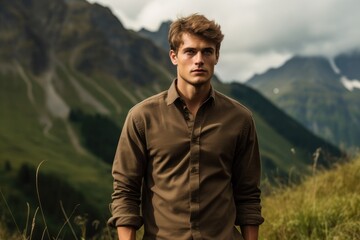 Adventurous young model wearing an outdoor shirt, mountainous backdrop