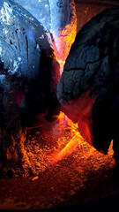 Charcoal braai briquettes in fire glowing red hot and creating heat for cooking and warmth