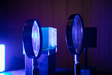 Optical lenses on stands in blue light in laboratory