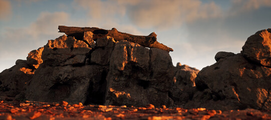 Fallen dead tree trunk on sandstone rock formation during sunset under a blue sky with some clouds.
