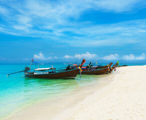 Fototapeta na wymiar Thai traditional wooden longtail boat and beautiful sand beach in Thailand. Traveling concept.