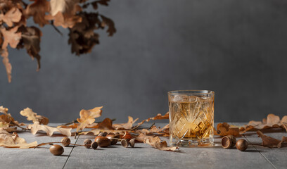 Whiskey in frozen glass with ice on a grey stone table.