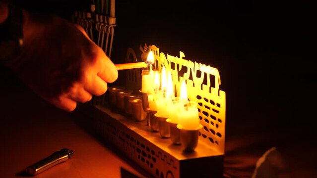 Person lighting the Shamash candle of the forth day of Hanukkah festival