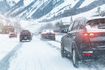 Scenic view snow covered city highway slippery mountain alpine road drive cars moving fast speed...
