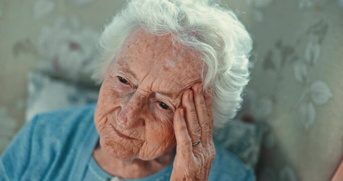 Stress, headache and senior woman on a chair with memory loss, fear or doubt, worry or overthinking. Anxiety, migraine and elderly female person in a nursing home with regret, loss or abandoned