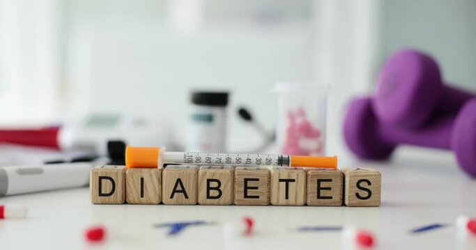Word diabetes on cubes with syringe and pills on table. Insulin injection and blood sugar control
