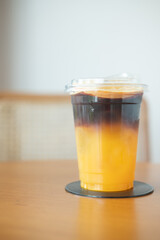 Orange juice and espresso, Americano coffee in glass. Trendy summer coffee drink with ice. Iced drink.