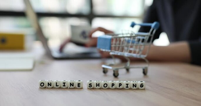Female hand with keyboard and shopping cart text online shopping. Online shopping on Internet
