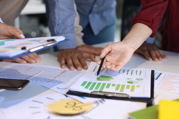 Team of employees working with charts at table, closeup. Startup project