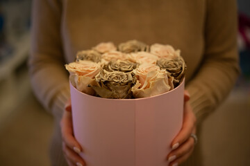 Bouquet of Pink and gold roses in a pink gift box. Floral romantic composition with jewelry for...