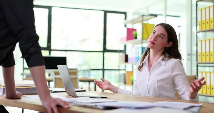 Doubtful business woman shrugging her shoulders in conversation with boss. Emotions of doubt and insecurity at work