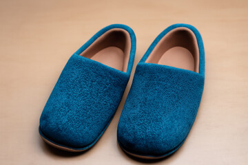 slippers. women's blue soft fluffy home slippers stand on the wooden floor, top view