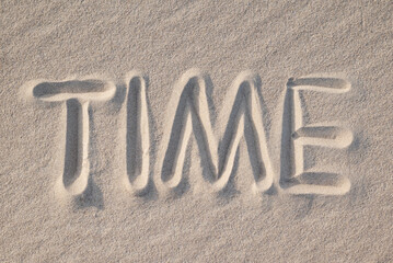 Word Time drawn on sand, close up. Concept of passing hours and years, timelasting periods, fast...