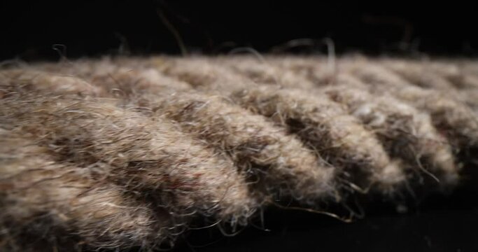 Coil of brown rope on a black background. Polyamide braided rope