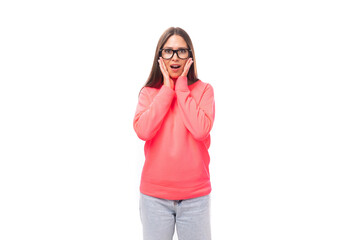 young excited european lady with dark long straight hair in a pink sweater on a white background with copy space