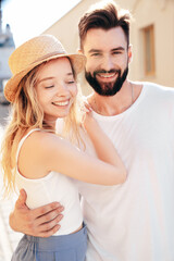 Smiling beautiful woman and her handsome boyfriend. Woman in casual summer clothes. Happy cheerful family. Female having fun. Couple posing in street at sunny day. Having tender moments. In hat