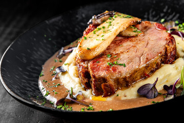 Grilled beef steak with mashed potato and sauce in plate