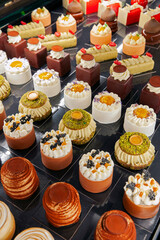 Composition with assorted desserts, variety. Set of sweet dessert: pistachio, meringue, cream, nuts, fruits, chocolate, mousse. Dessert display window of pastry shop. Confectionery concept, banner