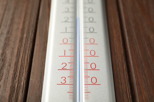 Modern weather thermometer on wooden background, closeup