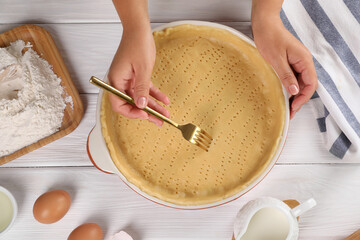 Woman making quiche at white wooden table, top view