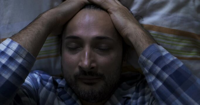 Top view: A man wakes up and rubs his face with his hands. Good mood and positive attitude