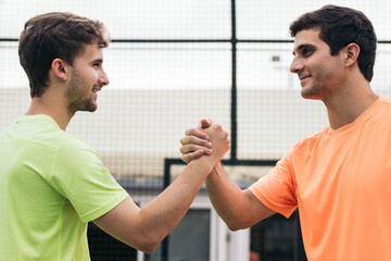 two young man paddle players shaking hands after game. fair play
