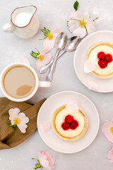 Delicious red raspberry strawberry whipped creamy tartlets,cakes.gourmet confection dessert on plate with latte coffee,milk.sweet tasty pastry baked pie cheesecake with ripe berries on gray table