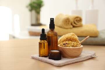 Dry flowers, bottles of essential oils and jar with cream on wooden table indoors, space for text. Spa time