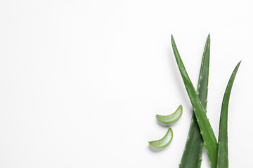 Cut aloe vera leaves on white background, flat lay. Space for text