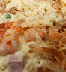 rice and shrimp. rice with shrimp. meal made of rice, shrimp, ham and crispy potatoes. food with selective focus.