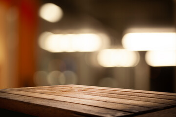 High quality photo of a wooden table against an abstract blurred background of restaurant lights.