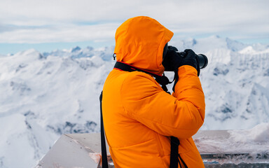 A photographer in the cold Alps regions tries to take a photo for journalism in a strong winter...