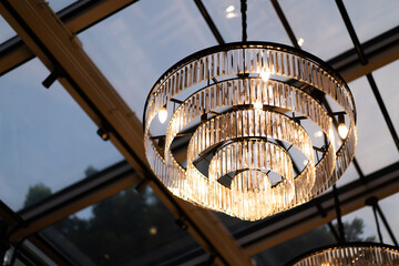 Luxurious crystal chandeliers on the ceiling of the loft style restaurant