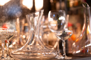 Clear glasses and pitchers in various shapes are lined up for the party. backlight reflection bokeh