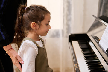 Little girl having individual piano lesson,