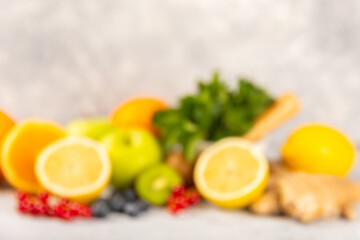 Oranges, apples, lemons, kiwi, mint, red currants and blueberries on a textured cement background. Fruits and berries. Vitamins for immunity. Place for text. Copy space.