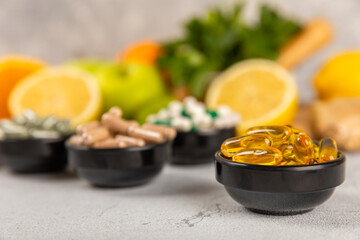 Vitamins and supplements. Variety of vitamin tablets in a jar on a texture background.Multivitamins with fresh and healthy fruits.Food supplements. Flat lay. Space for text.Copy space