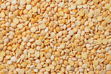 Uncooked Polished Split Peas Background. A Culinary Canvas of Dry Yellow Peas, Creating a Lively and Textured Background for Gourmet Cooking. Scattered Raw Polished Peas. Healthy Eating Ingredients