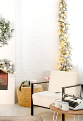 A white armchair and a table with a typewriter in a cozy, bright interior. Business concept