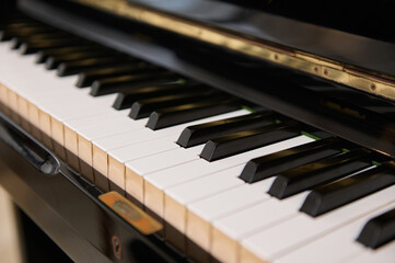 Close up shot of black wooden vintage grand piano keyboard, with black and white keys. Still life