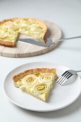 Piece of tasty leek pie served on white table