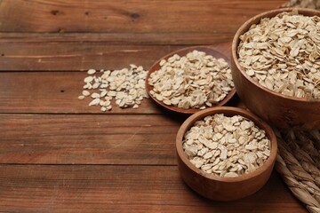 Bowls with oatmeal on wooden table. Space for text