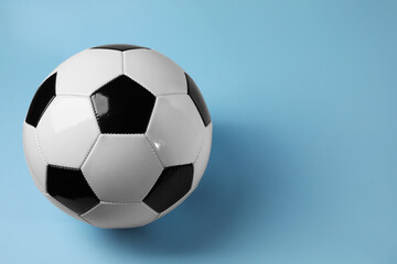 One soccer ball on light blue background, space for text. Sports equipment