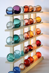 Shelf with glass marbles in diferent colors.
