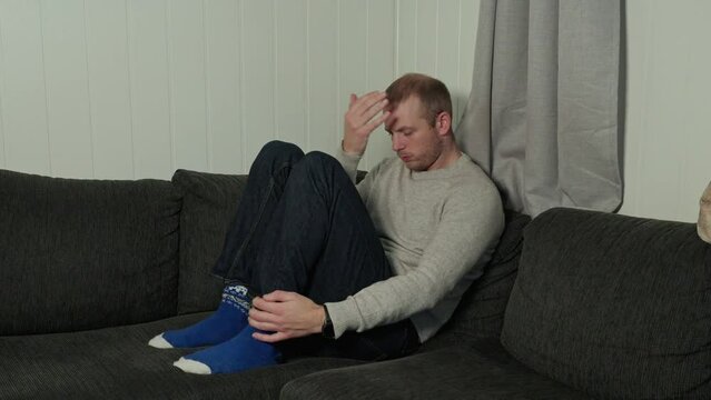 Depressed Man Emotional Struggle in Corner of Sofa